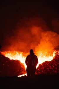a man standing in front of a large fire